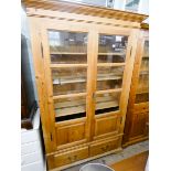 A modern pine glazed bookcase with two drawers under 3'9 wide