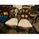 A pair of Victorian walnut dining room chairs standing on cabriole legs with upholstered seats
