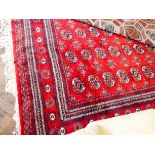 A red and patterned Bokhara rug 11' x 8'3