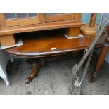A large oval mahogany coffee table on refectory style base