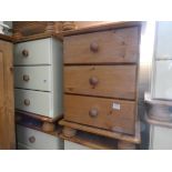 A pair of modern pine and cream three drawer bedside chests