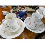 Two floral and butterfly decorated toilet jugs and bowls and a pottery toilet set