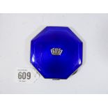 A silver octagonal compact with engine turned decoration and deep blue enamel,
