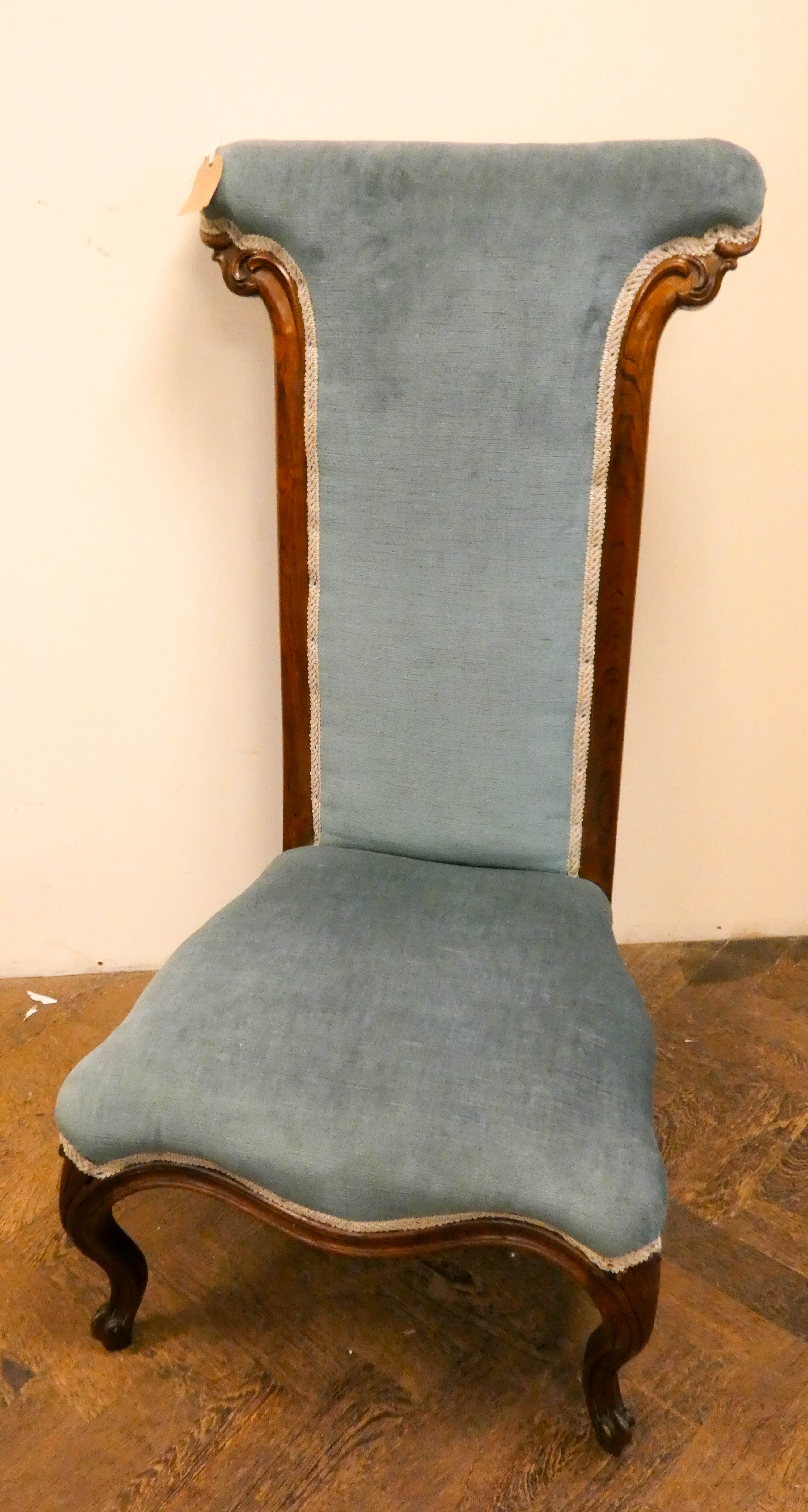 A Victorian rosewood framed prie dieu chair standing on cabriole legs with blue upholstered seat