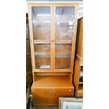 A 1970's teak glazed bookcase with cupboards under 2'6 wide