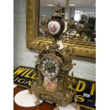A reproduction French mantle clock in decorative brass case with Sevres style panels 20" tall