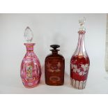 A collection of three 19th Century Bohemian ruby overlaid glass decanters,