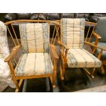 A pair of pale oak Ercol rocking elbow chairs with loose cushions