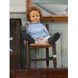 A child's chair and a large dressed doll