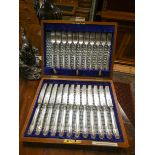 A set of twelve plated tea knives but only eleven forks in a fitted case