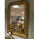 A large Victorian wall mirror in leaf decorated gilt frame 40" x 28" overall