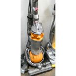 A yellow and silver Dyson ball upright vacuum cleaner