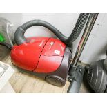 A red Phillips cylinder vacuum cleaner