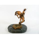 A modern copy of a Remington bronze desk paperweight on an oval marble base,