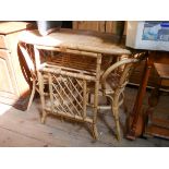 An oval bamboo and wicker conservatory table with a pair of matching chairs and a wicker tray table