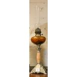 A late Victorian oil lamp with amber glass bowl on an onyx and metal base