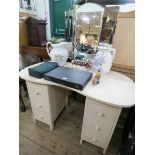 A cream painted kidney shaped dressing table with triple mirrors