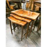 A nest of three walnut shaped front coffee tables