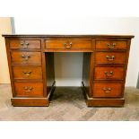 An Edwardian mahogany kneehole pedestal writing desk with green leather top,