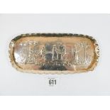 A silver pin tray embossed with a village scene of people dancing overall length 18 1/2 cms,
