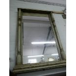A large wall mirror in distressed cream painted frame