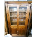A modern pine glazed two door bookcase with cupboards under 3'6 wide