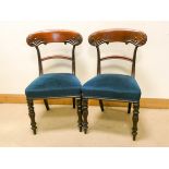 A pair of Victorian mahogany dining room chairs on turned legs with blue upholstered seats