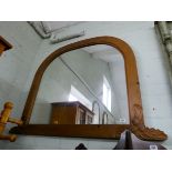 A large pine framed domed topped over mantel mirror