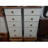 A pair of modern pine and cream five drawer bedside chests