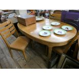 An oval Nathan pale teak extending dining table with fold away centre leaf and four matching ladder