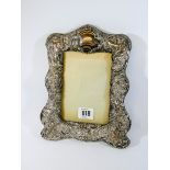 A highly decorated silver photograph frame with cherubs, leaves, swags etc,