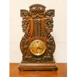 An eight day mantel clock in decorative leaf carved oak case 15" high 9 1/2 wide