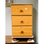 A modern pine three drawer bedside chest