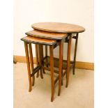 A nest of three oval walnut coffee tables