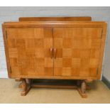 A light oak parquetry design two door sideboard standing on bobbin turned legs with cross