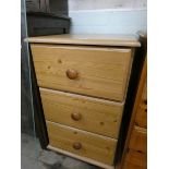 A modern pine three drawer bedside chest