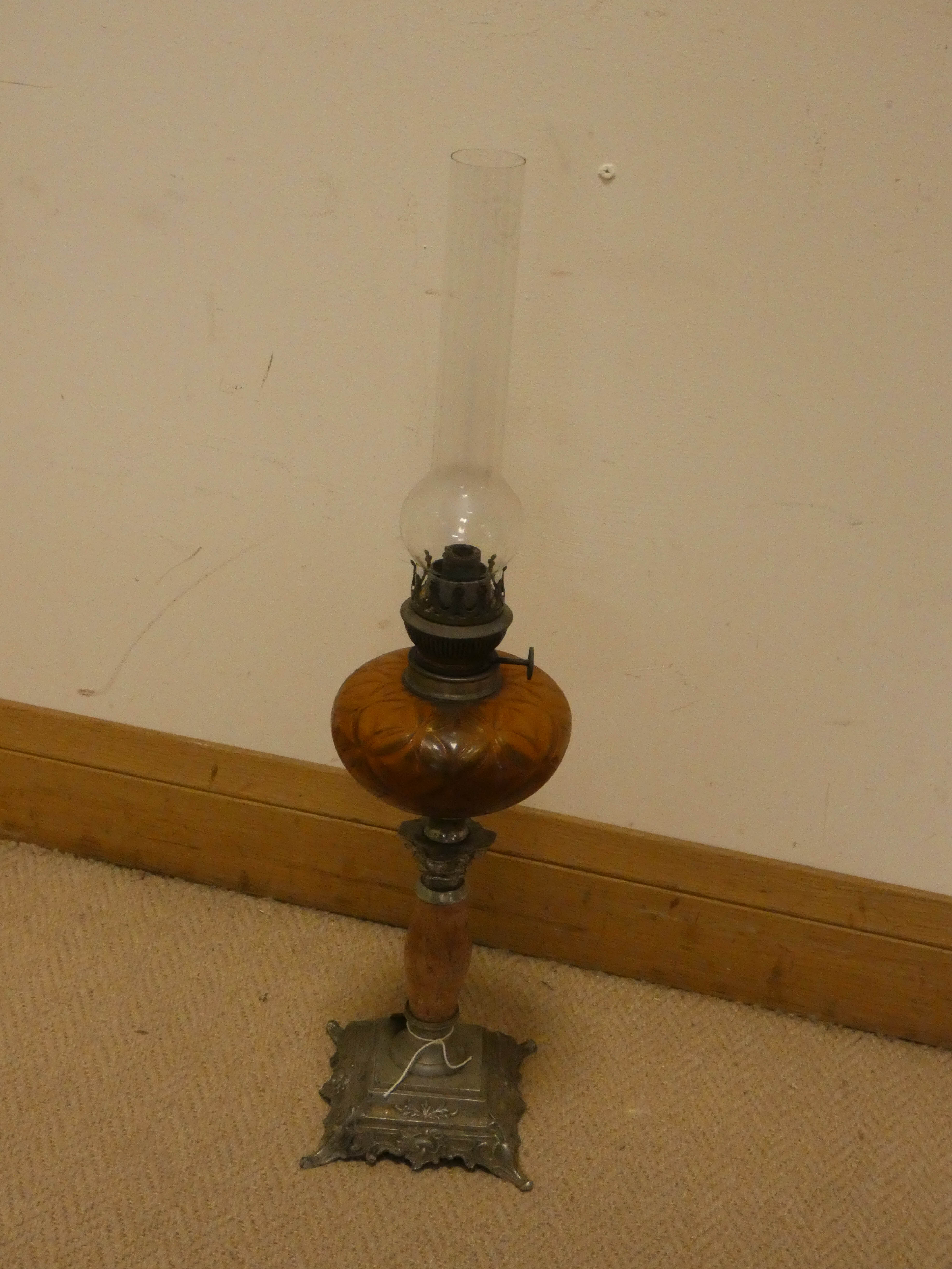 A late Victorian oil lamp with amber glass bowl on an onyx and metal base