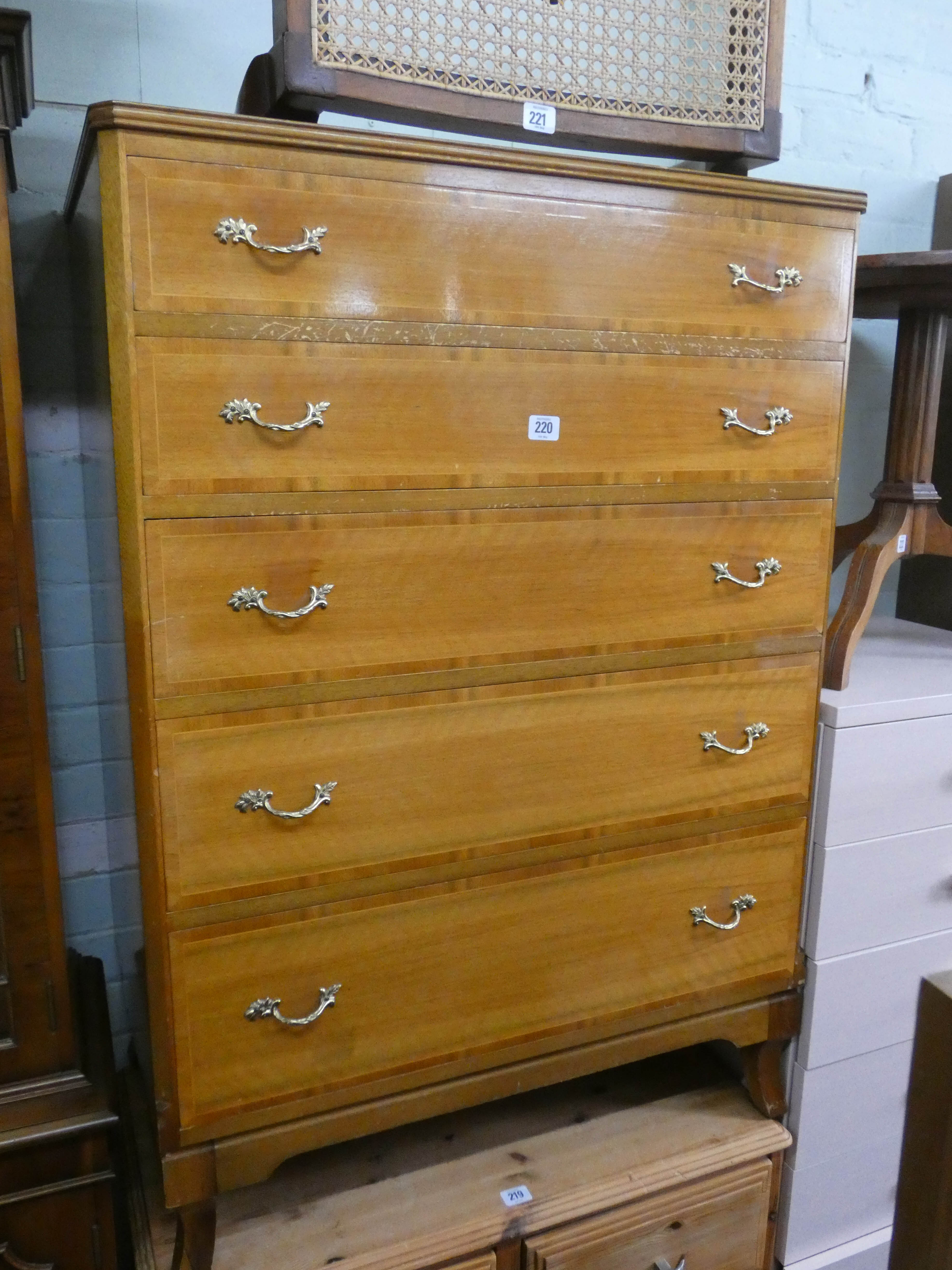 A pale mahogany chest of five long drawers with brass handles,