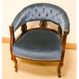 An Edwardian walnut tub shaped elbow chair upholstered in blue buttoned dralon