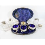 Case set of four silver plated salt cellars and four cut glass dressing table jars,