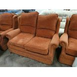 A two seater settee three piece lounge suite in terracotta covering with loose cushions