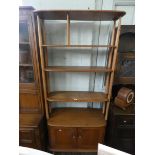 An Ercol pale oak room divider style open bookshelf with cupboards under,