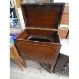 A Georgian style mahogany lift top drinks cabinet standing on square tapered legs with partly