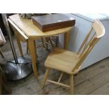 A modern light beech drop leaf kitchen table and a pair of matching stick back chairs
