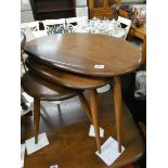 A nest of three oval shaped top Ercol coffee table in the Golden Dawn colour