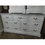 A long low modern white chest of seven drawers, matching the previous lot,