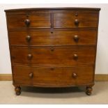 A mahogany bow front chest of three long and two short drawers with bun handles standing on turned