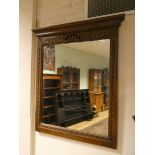 A large wall mirror in a carved oak frame,