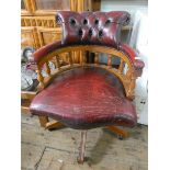 A red leather upholstered revolving office elbow chair