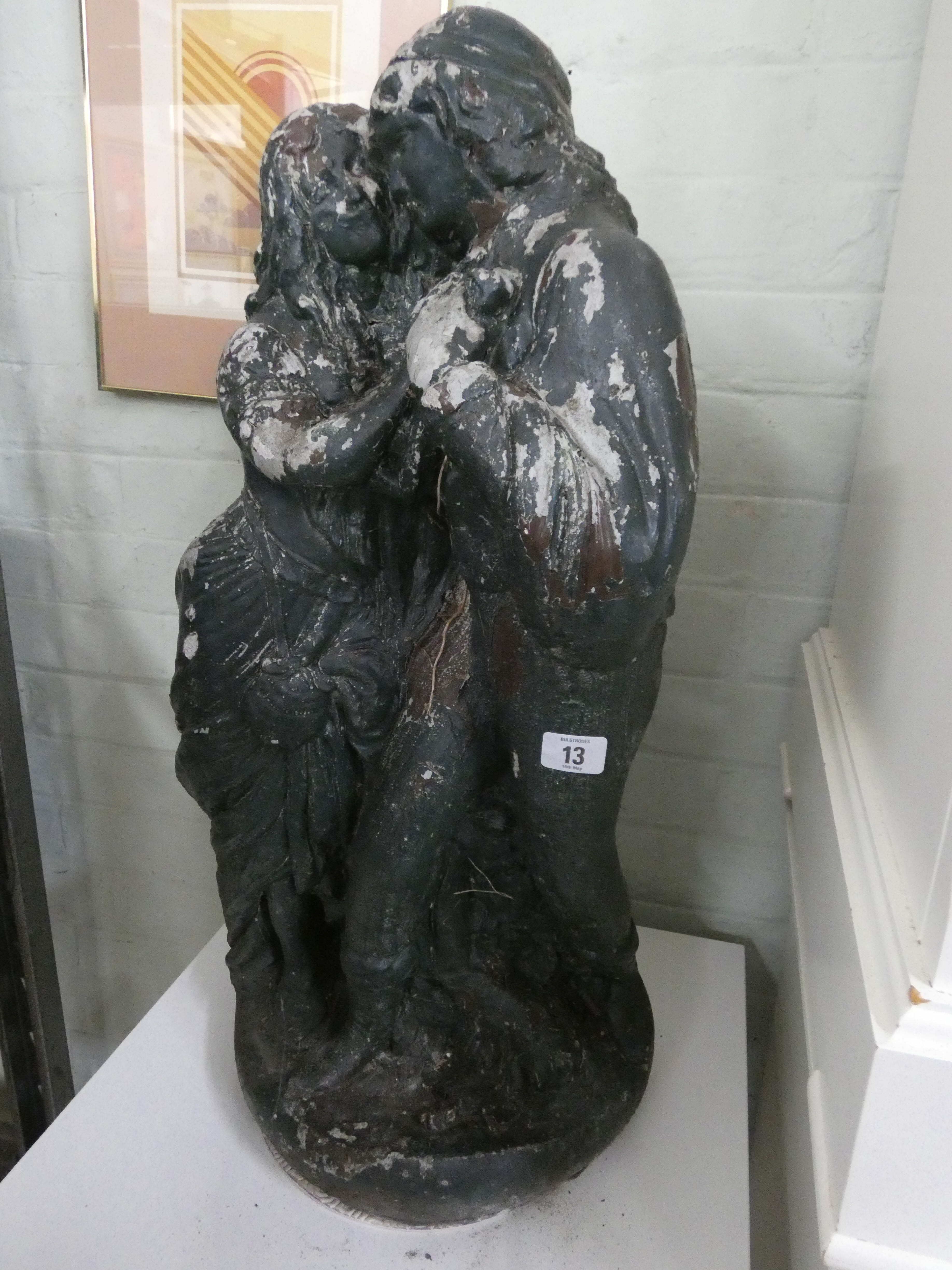 A reconstituted stone garden ornament of a couple, has been painted,